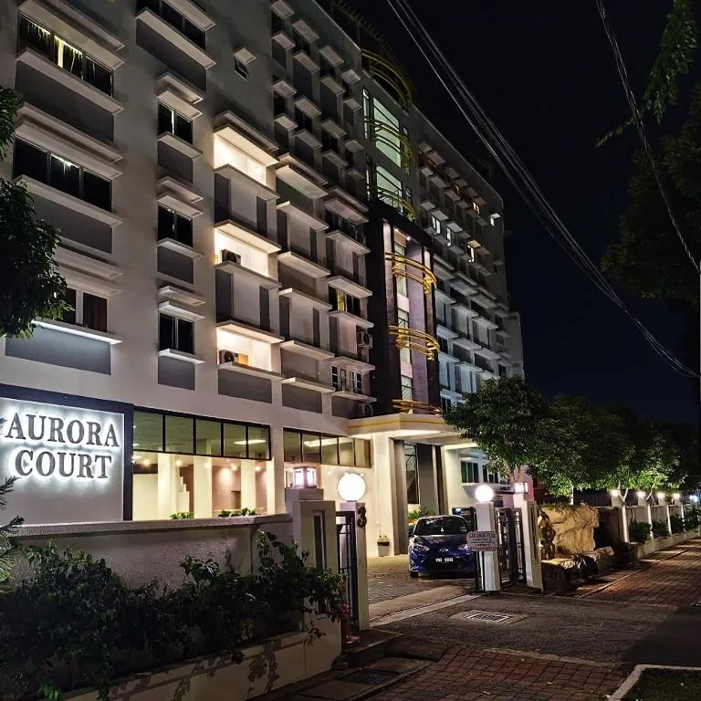 Aurora Court's illuminated sign and building facade at night