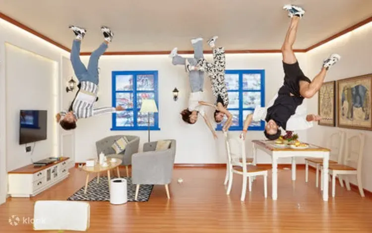 Visitors posing in an inverted living room at the Upside Down Museum