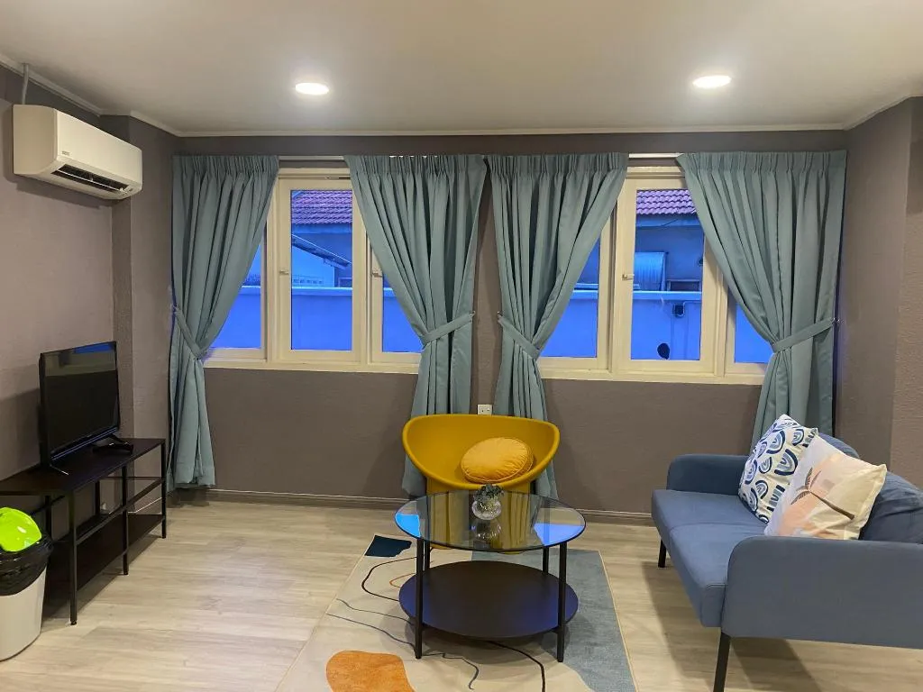 Sitting area with sofa, yellow armchair and Smart TV