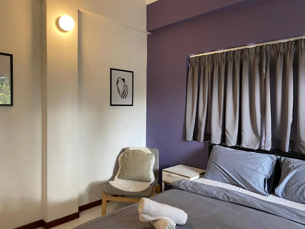 Bedroom with plum feature wall and armchair