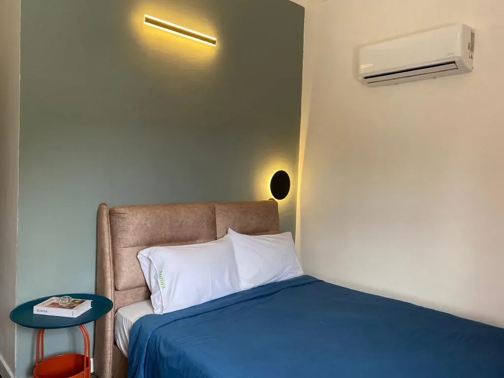 Bedroom with blue linens and wall lighting