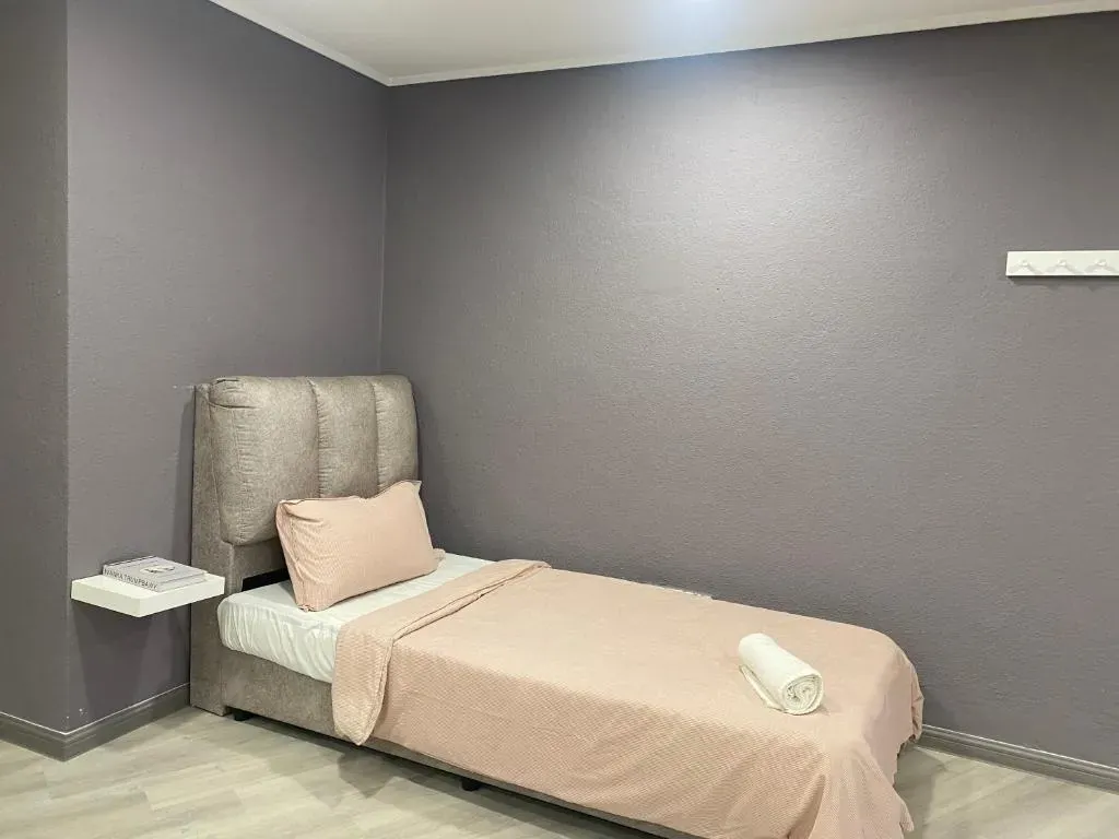 Single bed against a soft grey wall